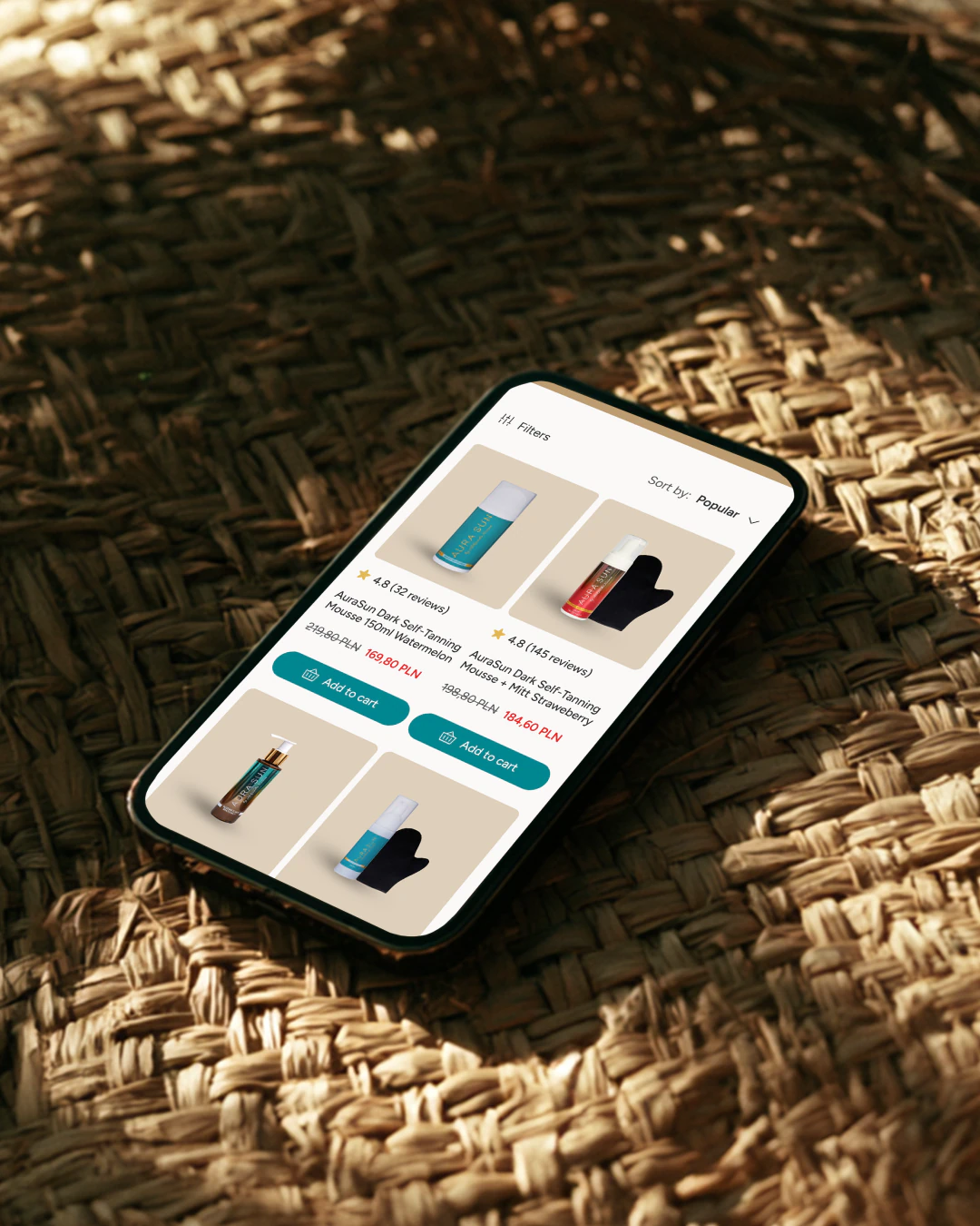 The product listing on a phone resting on a woven mat: tiles carrying the rating, review count, scent and an add-to-cart button.